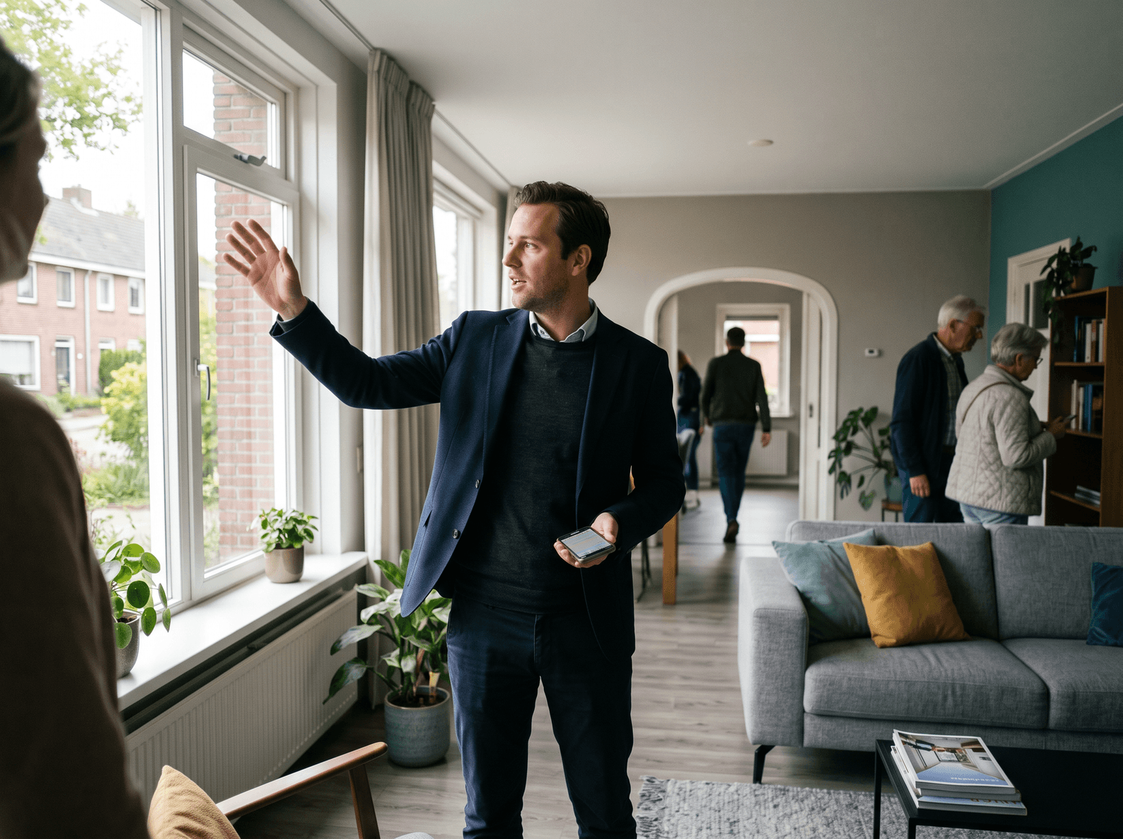 Makelaar laat een woning zien terwijl de telefoon in zijn jaszak gaat
